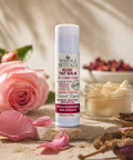 Whole Rituals Rose Tint Balm with pink roses and flowers in the background