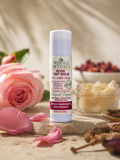 Whole Rituals Rose Tint Balm with pink roses and flowers in the background