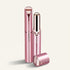 Three metallic pink cosmetic tubes on a warm off-white background, including one upright tube, one open tube showing the inner mechanism, and one cap lying in front.