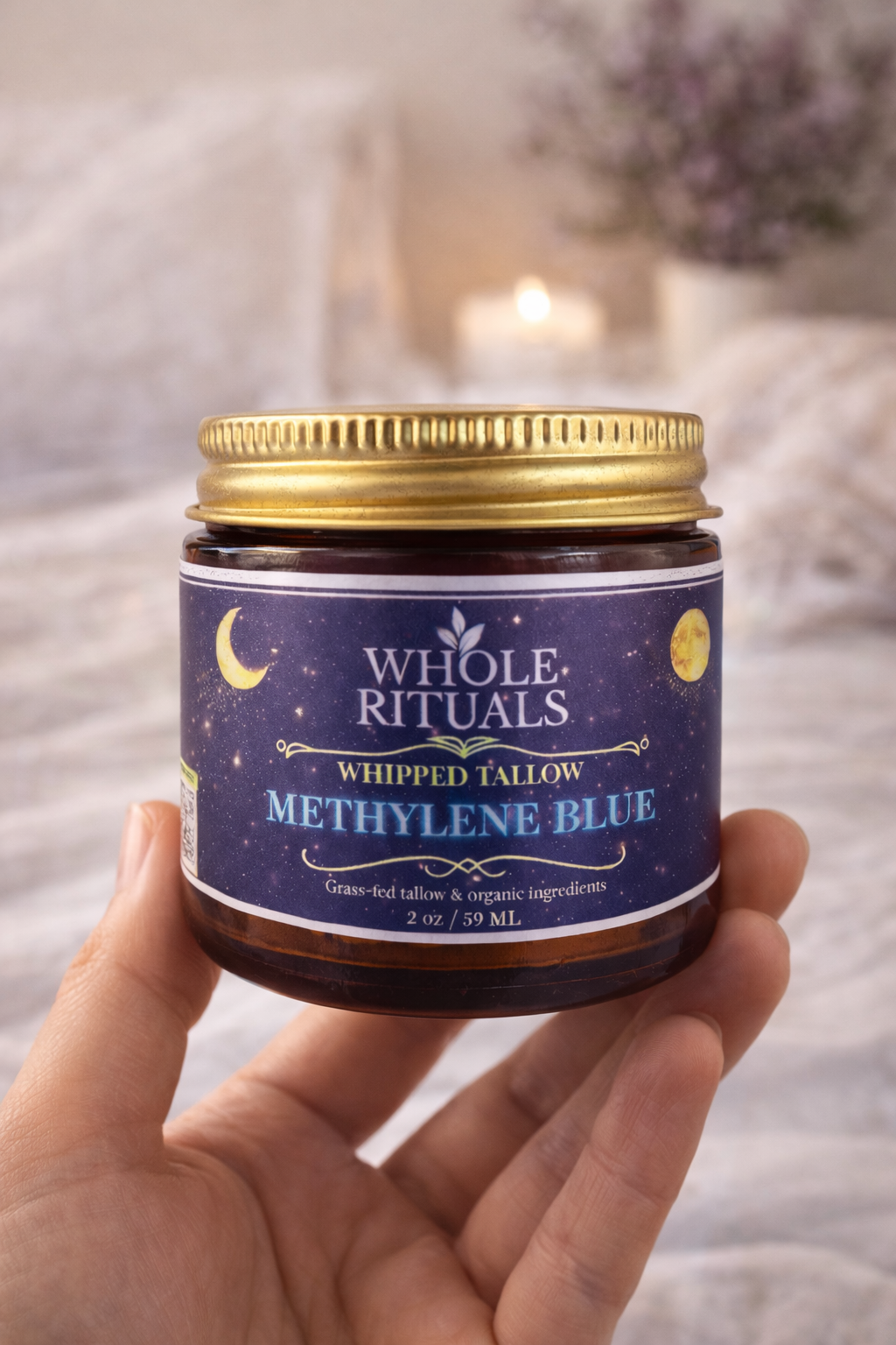 Jar of Whole Rituals Methylene Blue cream held by a hand with a soft blurred background