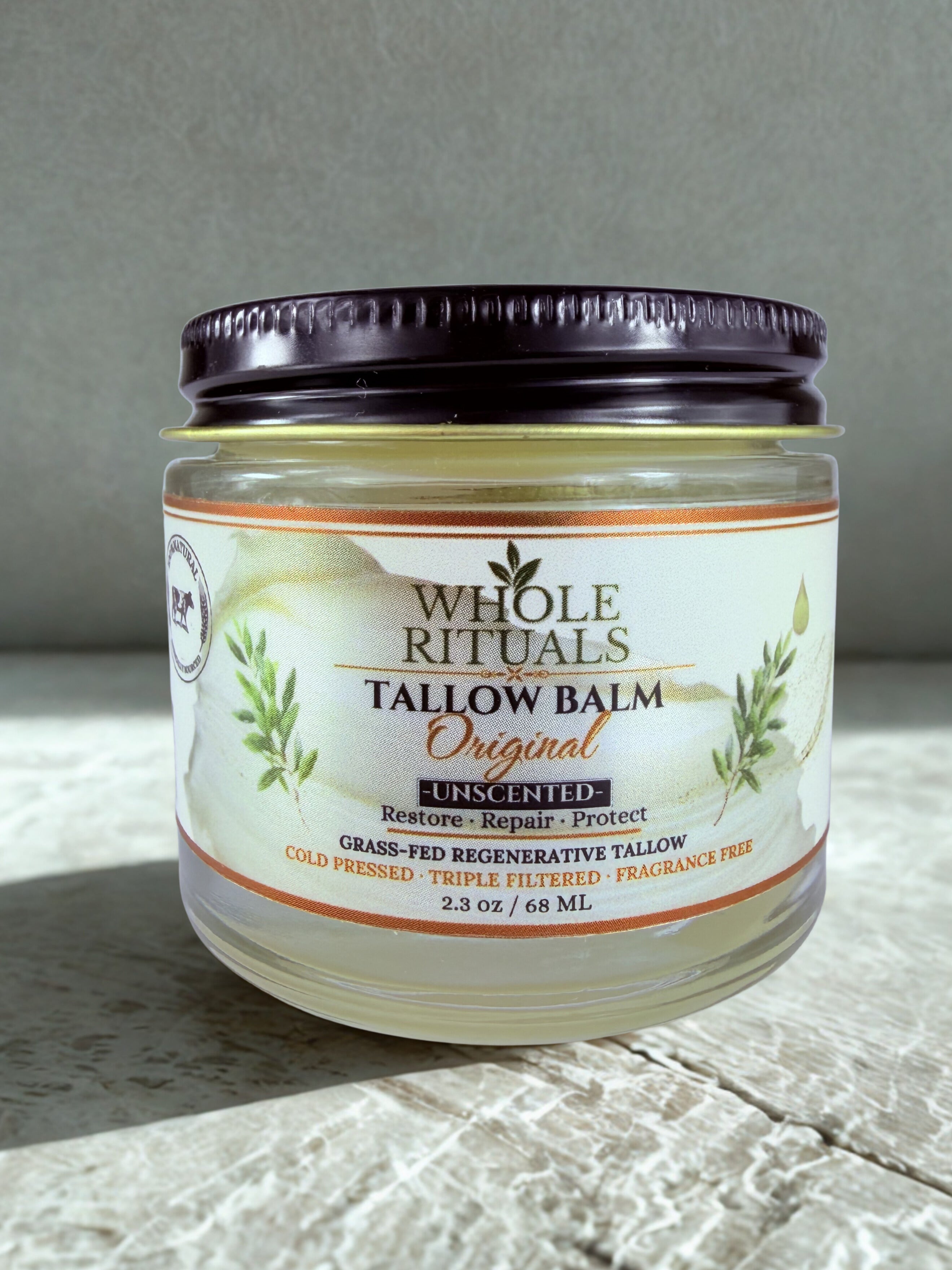Jar of Whole Rituals Tallow Balm on a textured surface with a neutral background