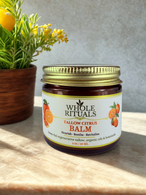 Jar of Whole Rituals Tallow Citrus Balm on a wooden surface with a plant in the background