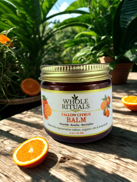 Jar of Whole Rituals Tallow Citrus Balm on a wooden surface with oranges and plants in the background