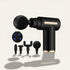 Black handheld massage gun with interchangeable attachments and a small digital display, shown on a light beige background with soft shadows.